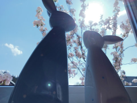 Oster Dekoration vor einem Fenster. Ein Kirchbaum im Hintergrund.