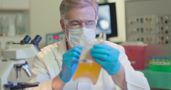 A medical professional working in a laboratory labels a bag of blood plasma preparation to be used to help the infected fight COVID19.