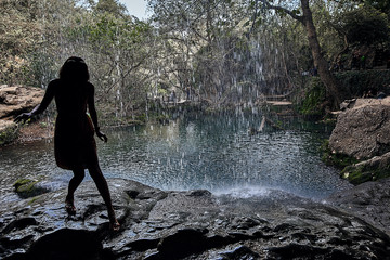 Girl touching water at Kursunlu Şelalesi waterfall, Antalya, Turkey