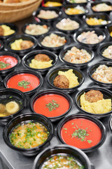 Food delivery. Different in plastic disposable lunch box with healthy natural food. Chicken broth, mashed soup, mashed potatoes with cutlet, seafood pasta, salads, pilaf with a fresh bun.