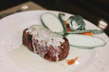 Filete bañado en salsa bechamel acompañado de verduras al vapor. 