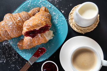 Breakfast with coffee and croissants on table