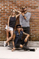 company of friends of skaters on the background of a brick wall.
