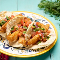 Mexican breaded fish tacos also called ensenada on turquoise background