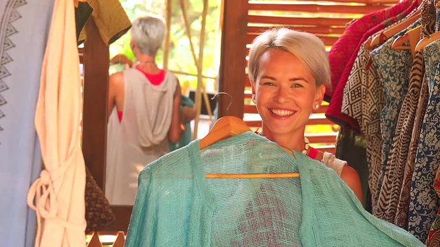 fashion consultant short haircut blonde choose dress at clothing store in Bali tropical shop