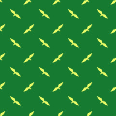 Yellow silhouettes of flying birds on green background: seamless pattern, wallpaper design, textile print. Vector graphics.