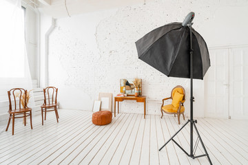 Interior photo Studio. Morning in light interior. Bright and clean interior design of a luxury living room with wooden floors, fireplace, sofa and chair . Stucco on walls