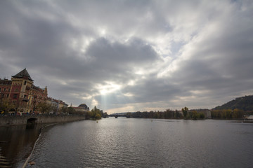 Fototapeta na wymiar Panorama of Prague, Czech Republic, seen from the Vltava river, also called Moldau, with Most Legii, or Legion Most, one of the landmarks of the city in background, during a cloudy sunset in autumn