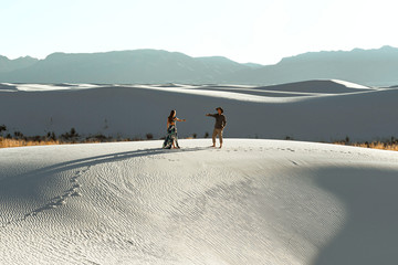 A couple dancing on sand dunes in the desert
