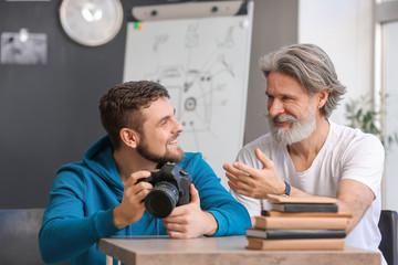 Mentor teaching young photographer in studio
