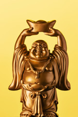 A small replica statue of The Buddha with a yellow background.  Yellow representing power, royalty, and prosperity. It also represents summer