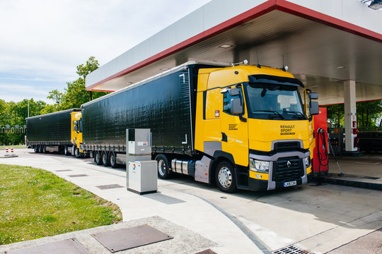 Nice, France - May 7, 2016: Two new modern Renault T520 Yellow Truck from the Formula One Sport Team at Total French gas station refueling carrying the fast turbocharged Renault F1 Grand Prix