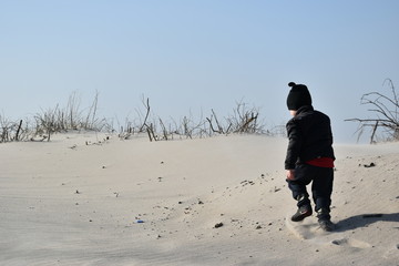 dziecko, plaża, wiosna, jesień, zabawa, słońce, hartowanie, czapka, kurtka, miki, czarny, piasek, radość, dzieciństwo, Kołobrzeg, wydmy, Morze Bałtyk, morze, bałtyckie,  spacer, pustynia, 