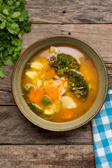 Vegetables soup with rice on wooden background