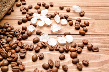 Coffee beans with sugar on wooden background