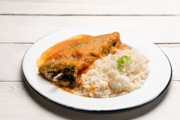 Mexican chili-stuffed poblano with rice on white background