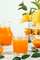 Delicious and nutritious freshly made orange juice in a sunny and flowery environment. Healthy, organic, detoxifying, vegetarian and vegan drinks. Space for text.