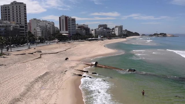 Large rusty pipeline revealed in Ipanema after a strong tidal wave washed away much of the sand with empty beach due to the COVID-19 Corona virus outbreak. [April 15, 2020]