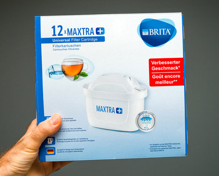 PARIS, FRANCE - JUL 15, 2019: Man holding New Brita water filter cartridge against gray background
