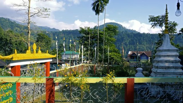 Beautiful view of Jhalong monastery at Dooars, West Bengal, India with blue sky and Himalayan mountains in the background.