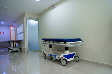 Patient bed on pathway in the hospital and wheelchairs