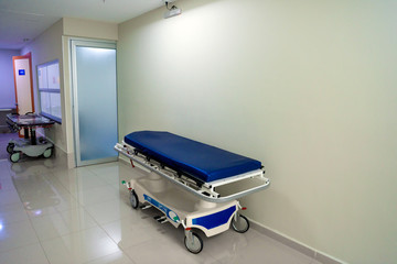 Patient bed on pathway in the hospital and wheelchairs