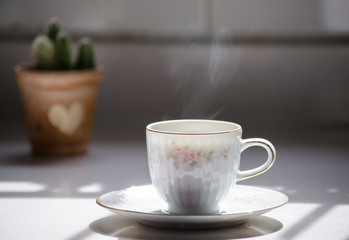 Beautiful porcelain cup of coffee with steam.