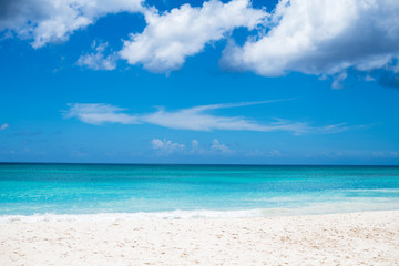 white sand beach on a blue sky with white clouds