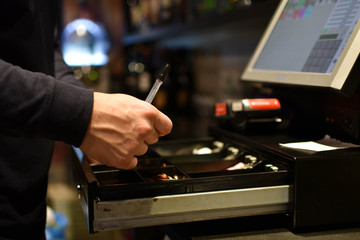 Waiter checking cash on a machine