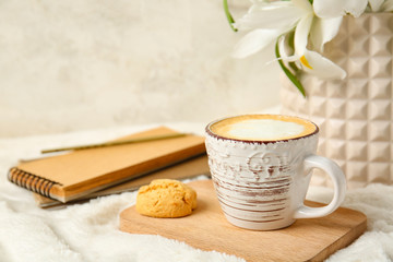 Obraz na płótnie Canvas Cup of coffee, flowers, cookie and notebook on soft plaid