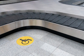 disabled travellers icon at baggage claim area in empty airport