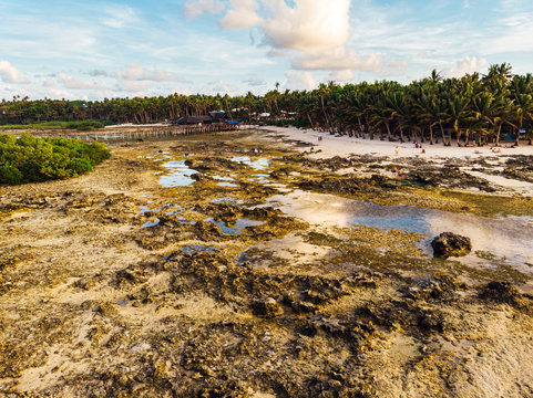 Aerial view of magestic landscape at sunset in the reef of Cloud9 at low tide with coral reef and transparent waters, Siargao Island, Philippines