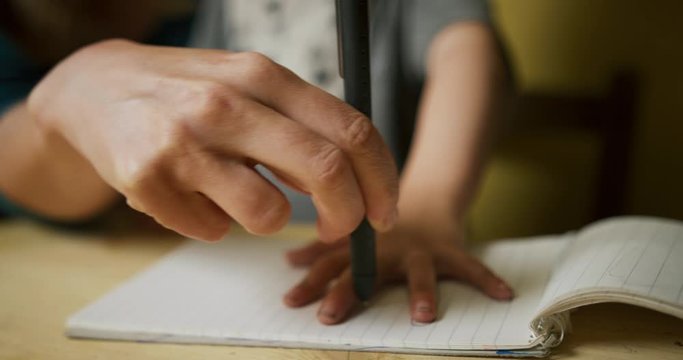 Young mother tracing her preschooler's hand on a piece of paper
