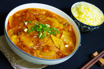 Sliced potato stew served with rice close up