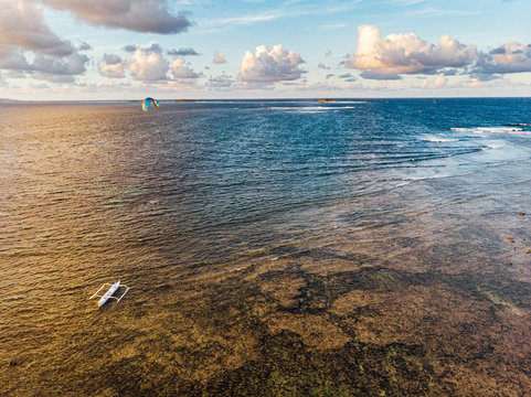 Active surfer practicing kitesurf in Jacking Horse beach close to Cloud9 boarwalk over the reef in low tide, Siargao Island,  Philippines