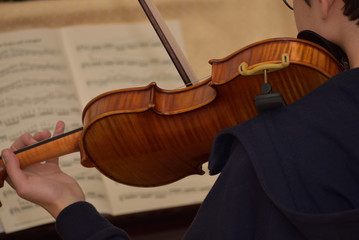 teenager boy practicing violin at home