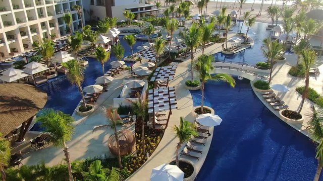 Luxury swimming pool area in romantic vacation resort in Punta Cana, Dominican Republic, aerial view of vibrant longes and hotel area