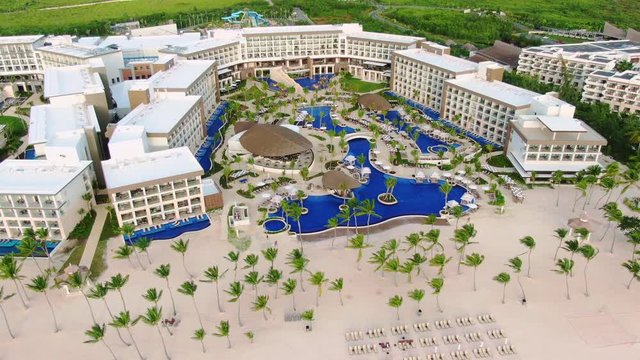 Exclusive holiday resort in Dominican Republic, panoramic aerial view of luxury hotel in Punta Cana with exclusive swimming pools and longes and idyllic sand beach with turquoise waters