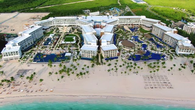 Luxury holiday resort with tropical beach, palm trees and turquoise sea, and exclusive swimming pool area, aerial view of Caribbean vacation destination in Dominican Republic