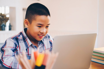 Young student boy makes his exercise sitting at table. Students studying and reading with books in library. Students doing his homework for elementary school. education and back to school concepts.