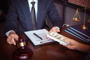 Justice and law concept. Gavel on sounding block in hand's Male judge at a courtroom, working with...