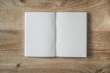 Opened blank white book on wooden table, top view