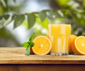 Orange juice and slices of orange on wooden desk