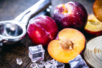 black plum cut in half on wooden background