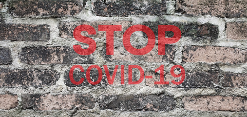 Stop COVID-19.  Warning wording Stop Covid-19 on blurred Red brick background