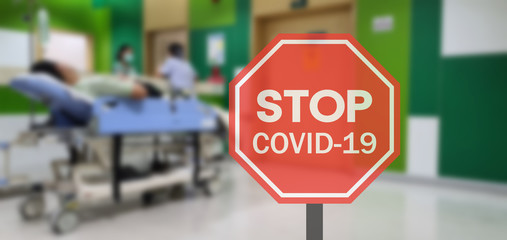 Stop COVID-19. Warning Stop Covid-19 sign on Thailand Hospital blurred background.