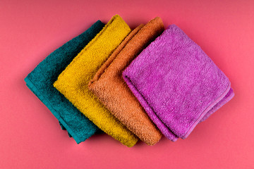 Multi-colored towels on the background. Pink, beige, yellow and blue flower towels. Place for writing. House order. flat lay.