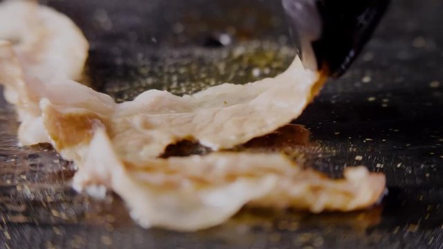 Grilling thin Korean samgyeopsal meat, macro close up 4K