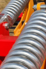 Steel spring in industrial or agricultural machinery. Part of hydraulic or pneumatic equipments. Technology concept
