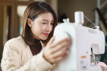 Happy woman enjoying work on sewing machine.